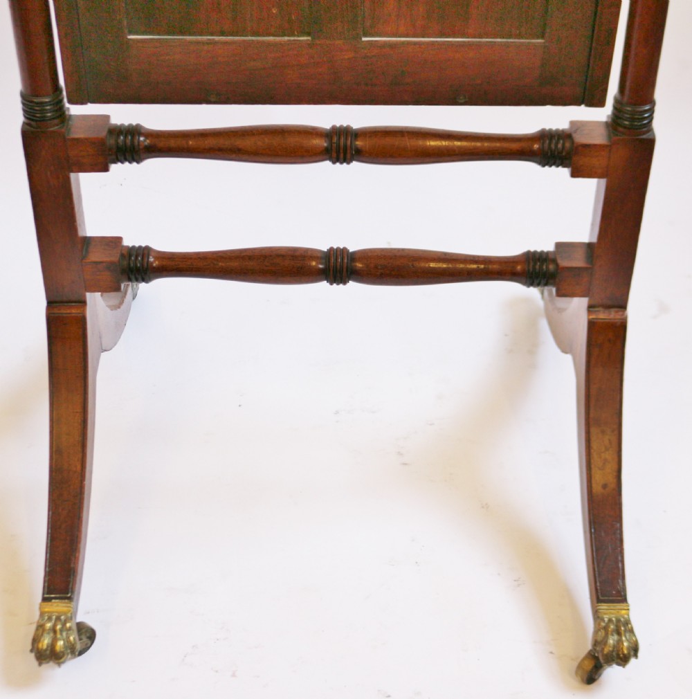 A Regency mahogany cheval mirror featuring a rectangular swivelling frame set between turned upright posts with brass castors. View IX