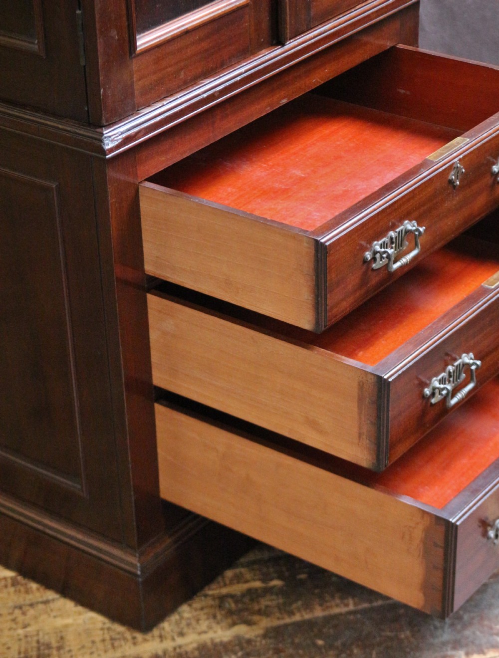 An Edwardian mahogany safe cabinet featuring twin upper panelled doors over three drawers with brass drop handles on a plinth base. View IV