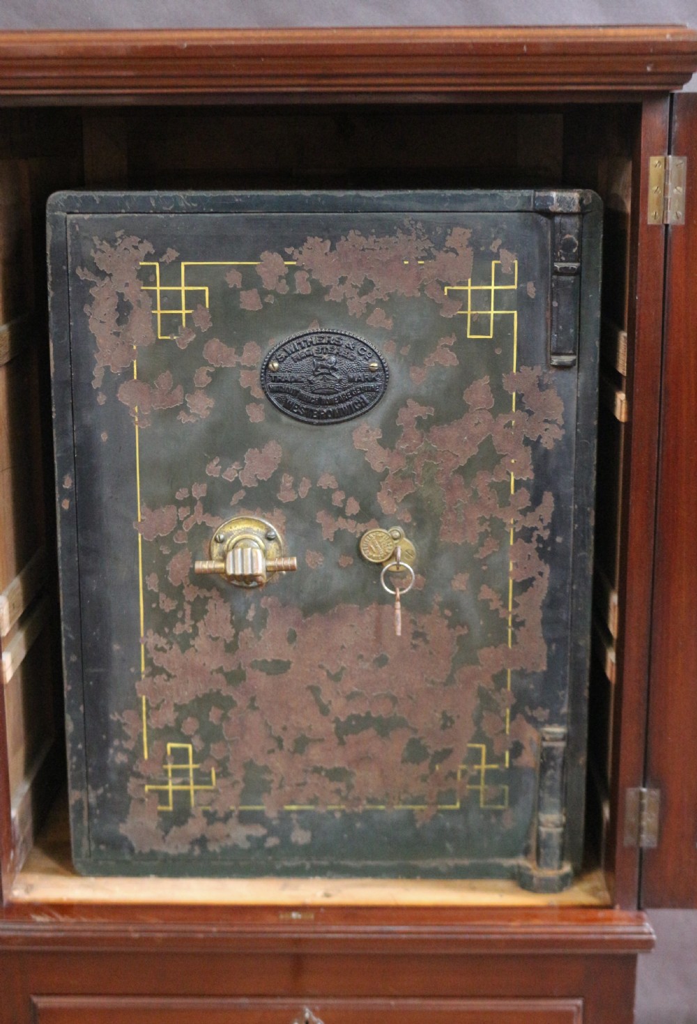 An Edwardian mahogany safe cabinet featuring twin upper panelled doors over three drawers with brass drop handles on a plinth base. View VIII