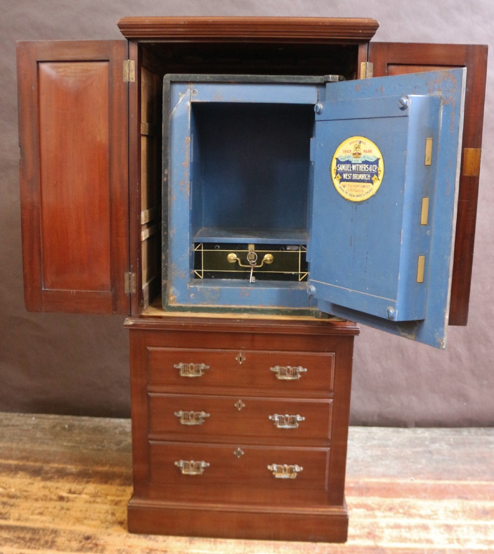 An Edwardian mahogany safe cabinet featuring twin upper panelled doors over three drawers with brass drop handles on a plinth base. View IX
