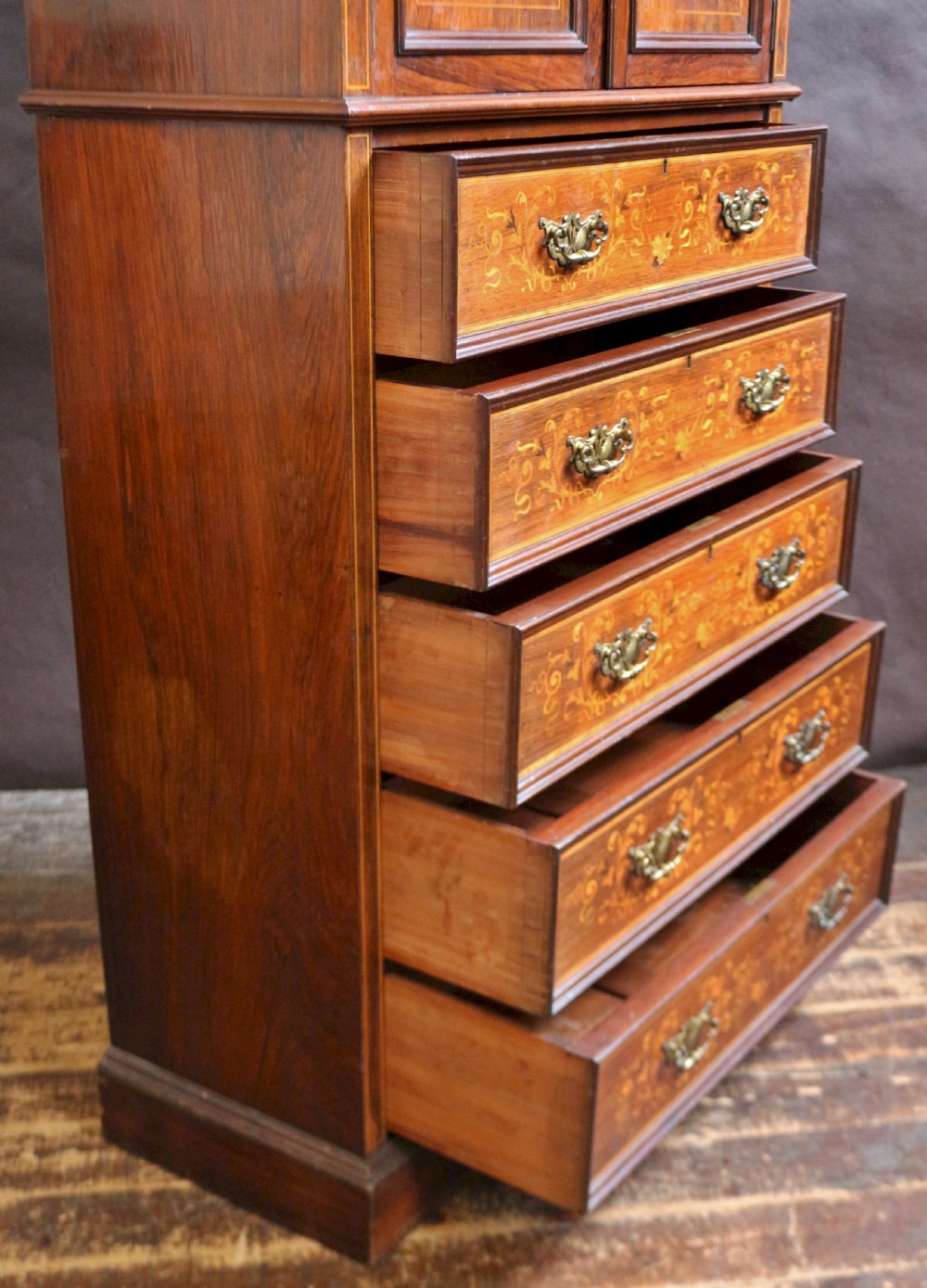 An Edwardian rosewood cupboard on chest featuring elaborate floral satinwood marquetry inlay, a two-door upper section, and five lower drawers with brass handles. View IX