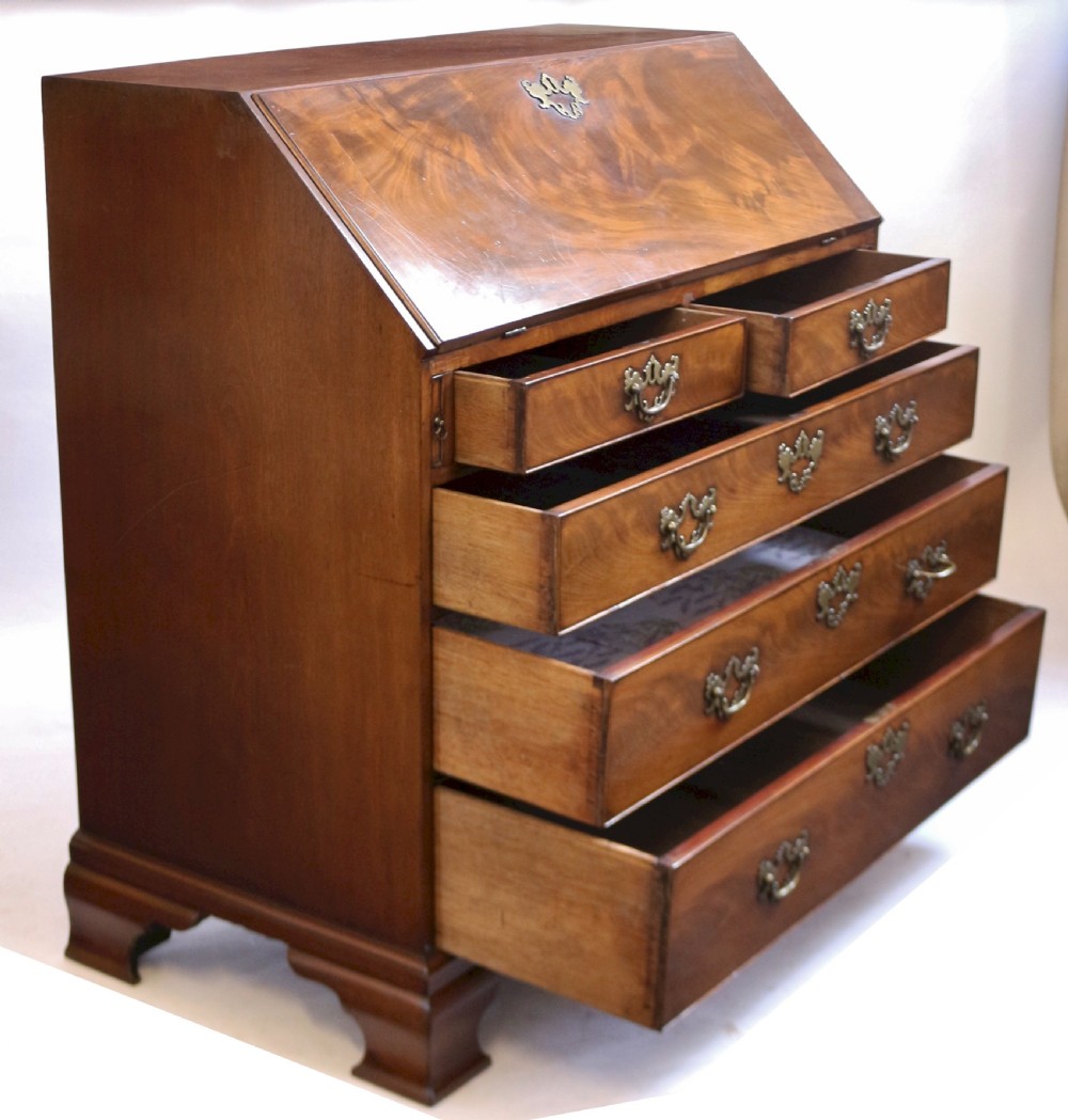 An 18th-century George III mahogany bureau with a slant-front writing slope, five graduated drawers, brass swan-neck handles, and bracket feet. View II