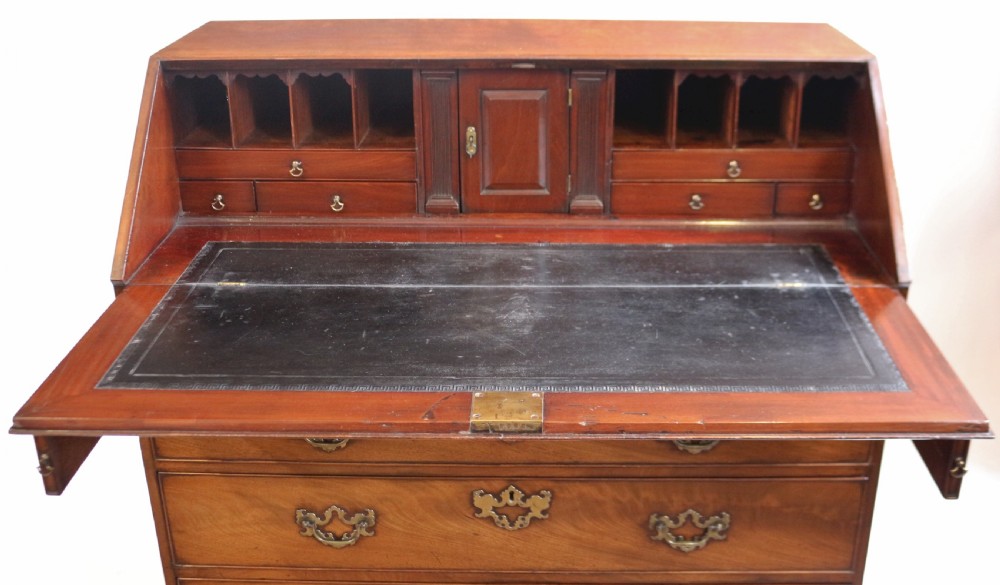 An 18th-century George III mahogany bureau with a slant-front writing slope, five graduated drawers, brass swan-neck handles, and bracket feet. View V