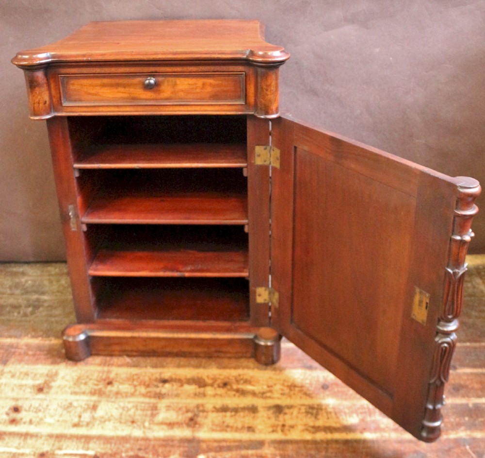 A William IV flame mahogany single-door bedside cupboard featuring a top drawer, carved acanthus leaf side columns, and a plinth base. View V