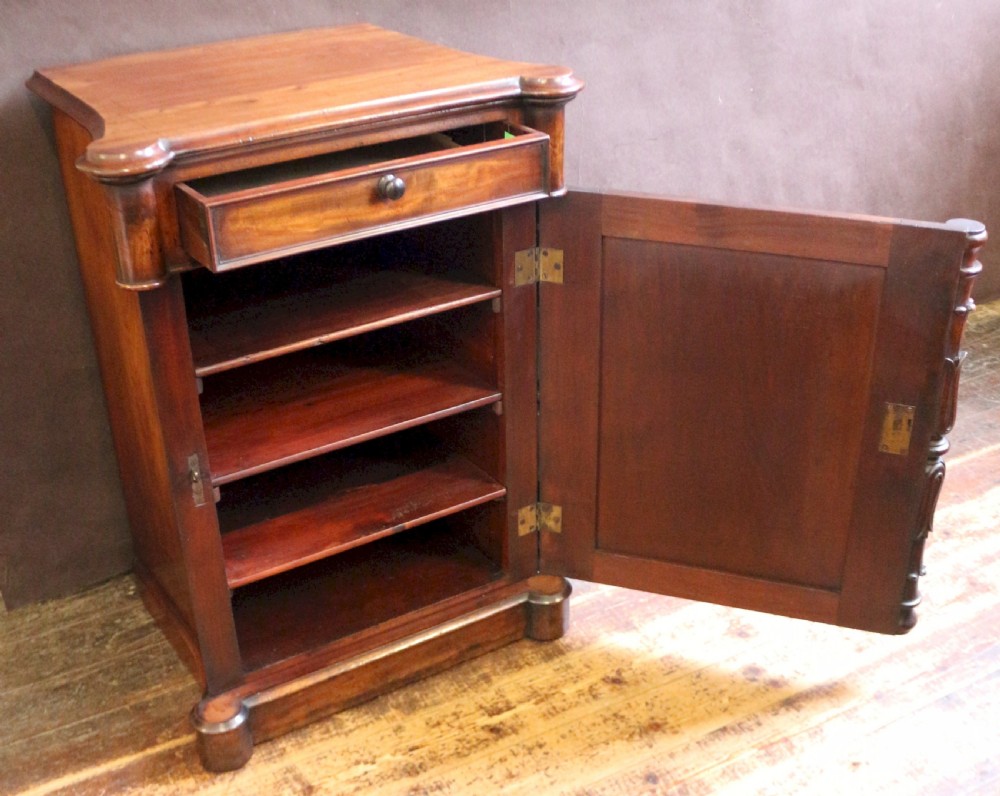 A William IV flame mahogany single-door bedside cupboard featuring a top drawer, carved acanthus leaf side columns, and a plinth base. View VI