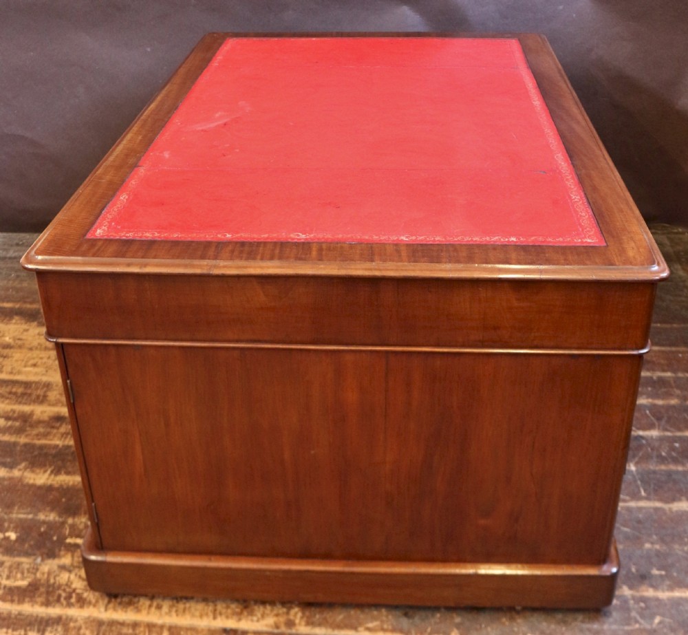 A Victorian mahogany three-part partners desk featuring a red leather writing inset and multiple drawers on two pedestals with turned wooden knobs. View VIII