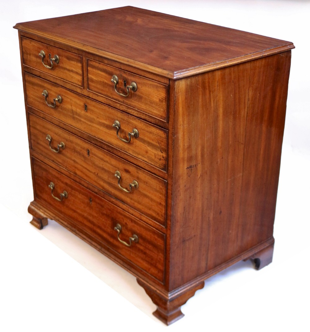 An antique Georgian mahogany chest of drawers featuring a two-over-three drawer configuration with brass swan-neck handles and shaped ogee bracket feet. View III
