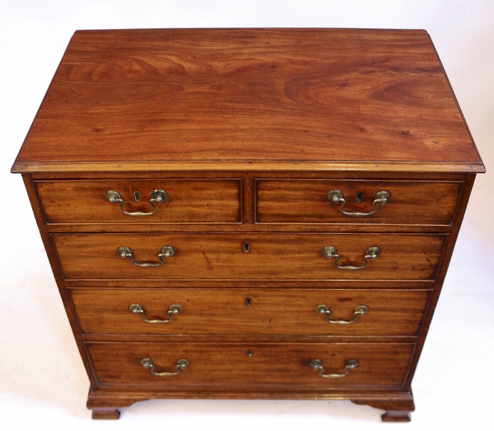 An antique Georgian mahogany chest of drawers featuring a two-over-three drawer configuration with brass swan-neck handles and shaped ogee bracket feet. View IV