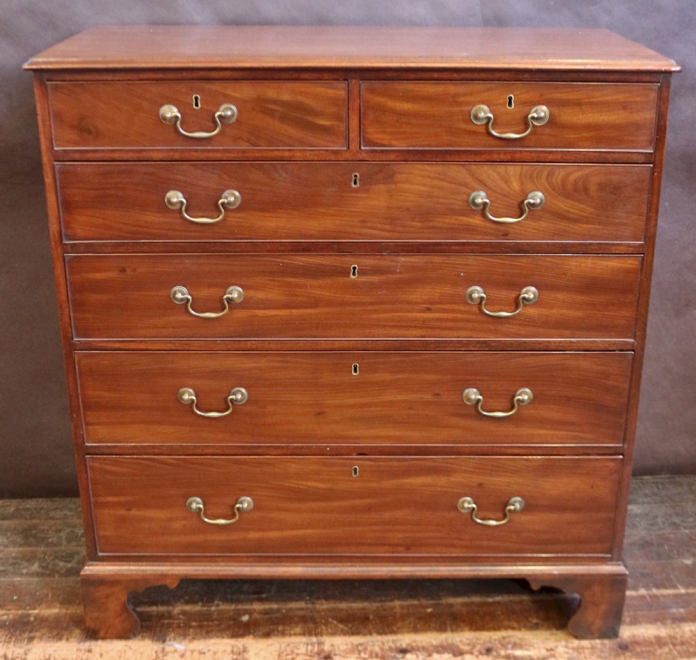 A Georgian mahogany chest of six drawers arranged in a two short over four long graduated design with brass swan-neck handles and bracket feet.