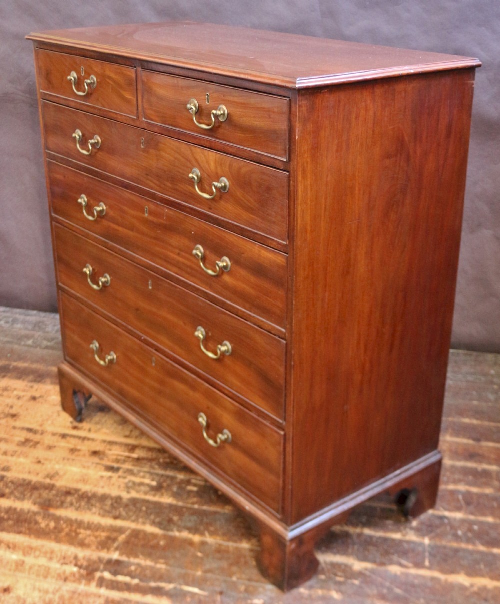 A Georgian mahogany chest of six drawers arranged in a two short over four long graduated design with brass swan-neck handles and bracket feet. View III