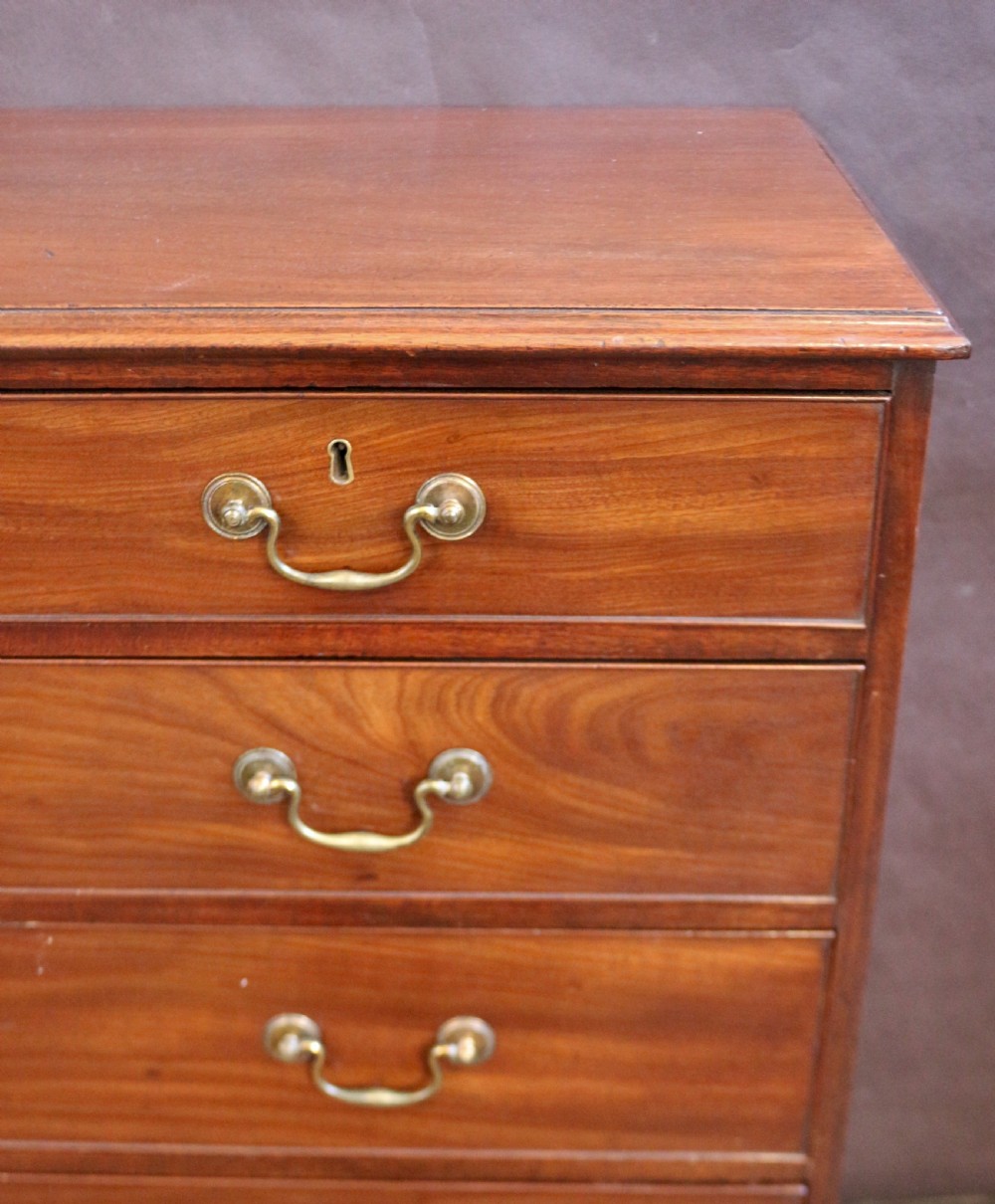 A Georgian mahogany chest of six drawers arranged in a two short over four long graduated design with brass swan-neck handles and bracket feet. View VI