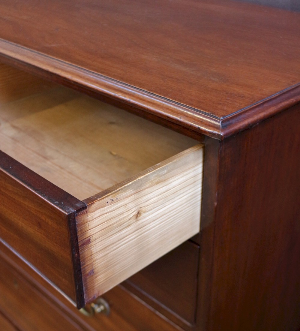 A Georgian mahogany chest of six drawers arranged in a two short over four long graduated design with brass swan-neck handles and bracket feet. View VII