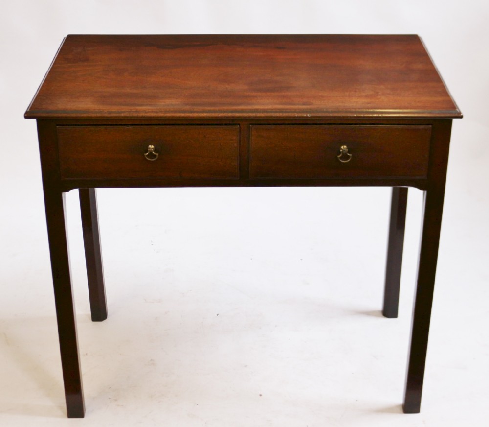 A George III mahogany side table featuring a flat rectangular top above two frieze drawers with brass handles, raised on four straight legs.