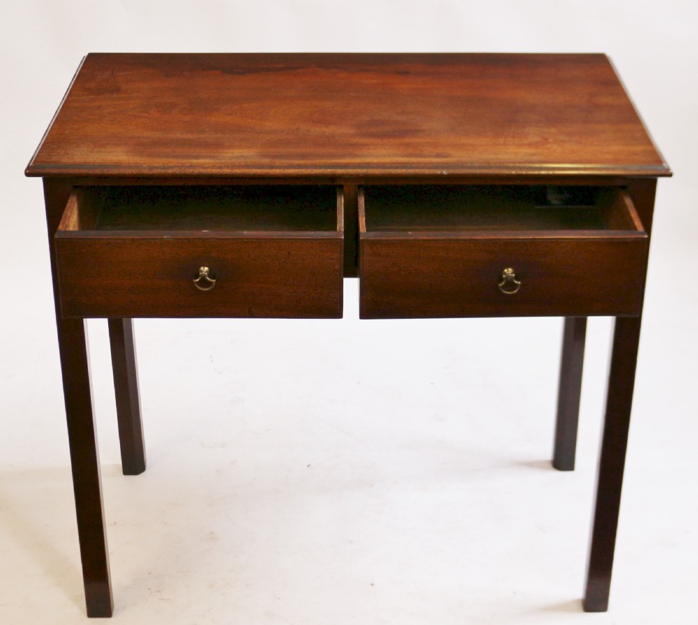 A George III mahogany side table featuring a flat rectangular top above two frieze drawers with brass handles, raised on four straight legs. View II