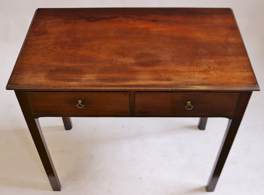 A George III mahogany side table featuring a flat rectangular top above two frieze drawers with brass handles, raised on four straight legs. View III