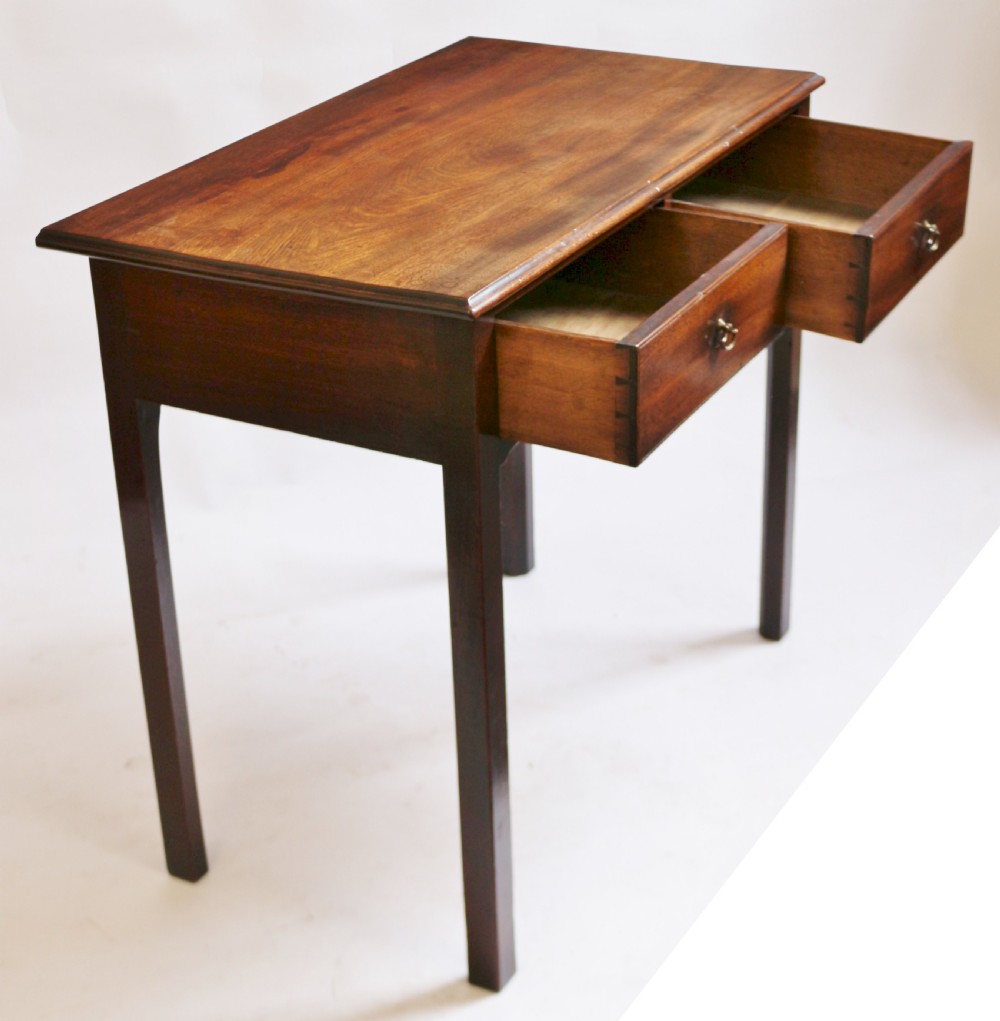 A George III mahogany side table featuring a flat rectangular top above two frieze drawers with brass handles, raised on four straight legs. View IV