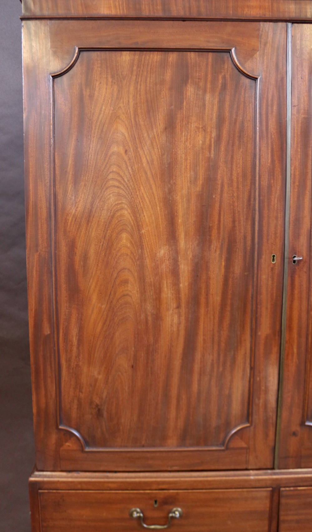A Georgian mahogany linen press featuring panelled double doors above a chest with two short and two long drawers raised on bracket feet. View VII