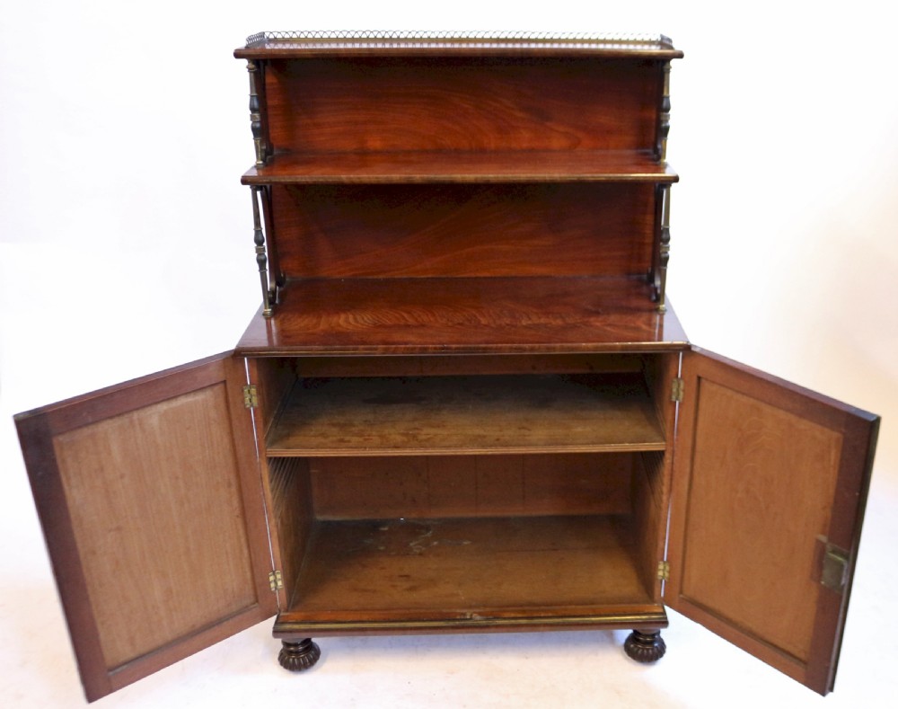 A Regency flame mahogany chiffonier featuring a two-door base cupboard, a two-tier shelf back supported by slender brass pillars, and a pierced brass gallery rail. View III
