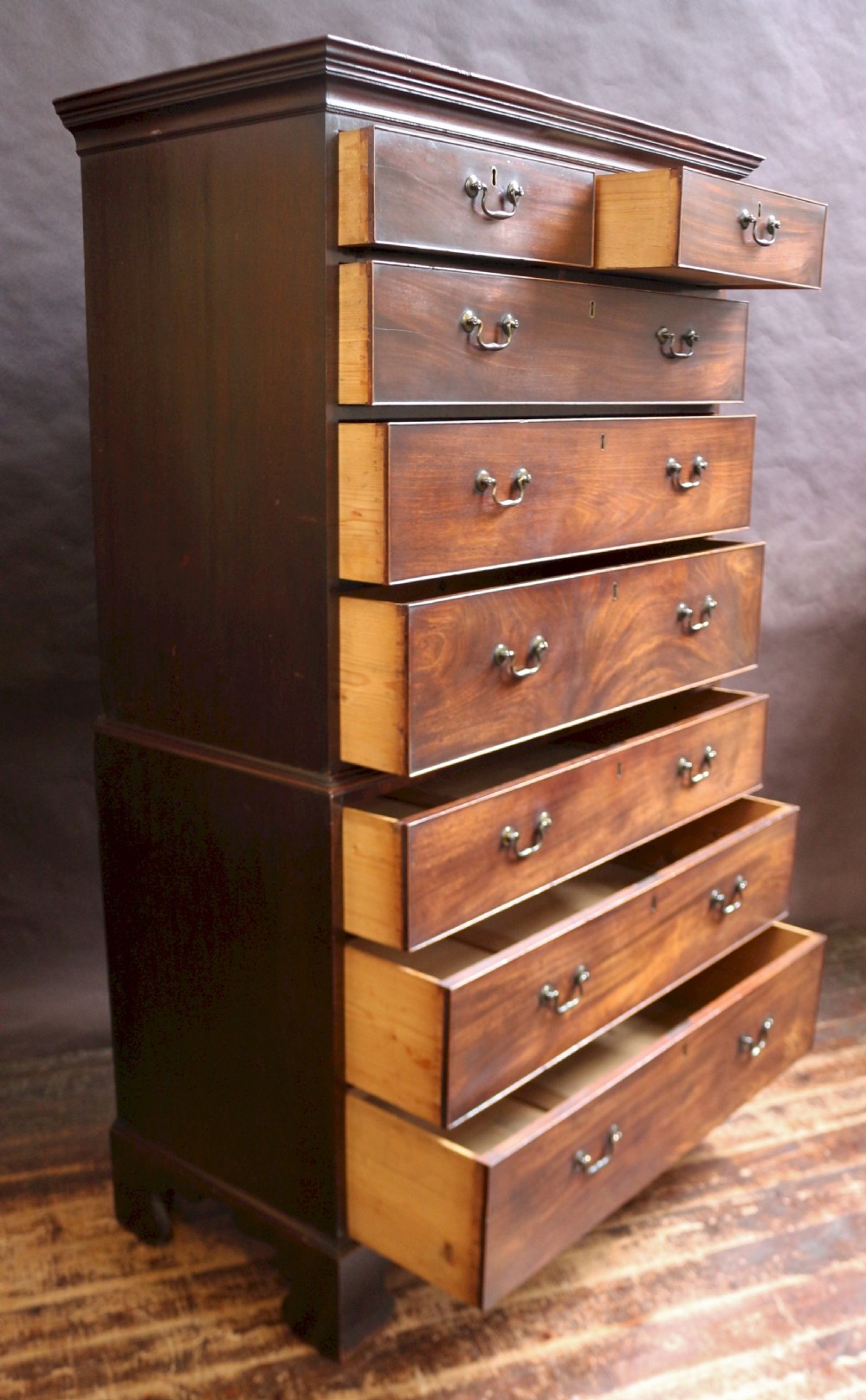 A George III mahogany chest on chest featuring two short over five long graduated drawers with brass swan-neck handles on bracket feet. View II