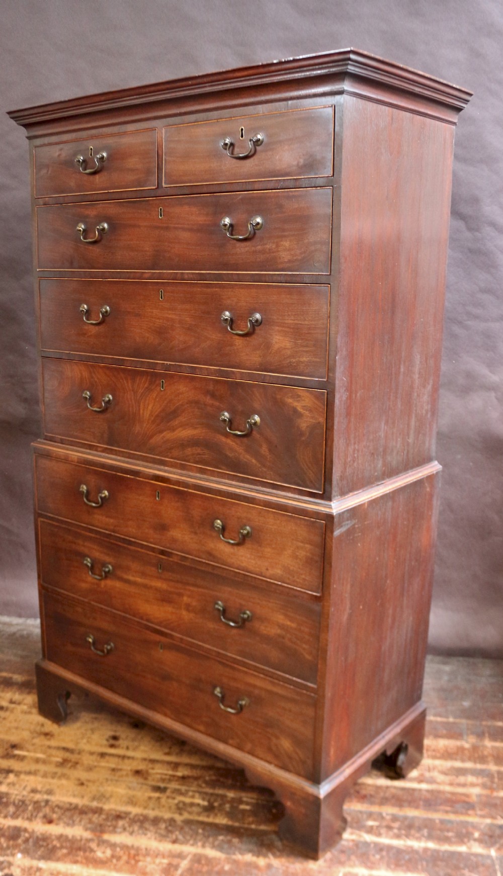 A George III mahogany chest on chest featuring two short over five long graduated drawers with brass swan-neck handles on bracket feet. View III