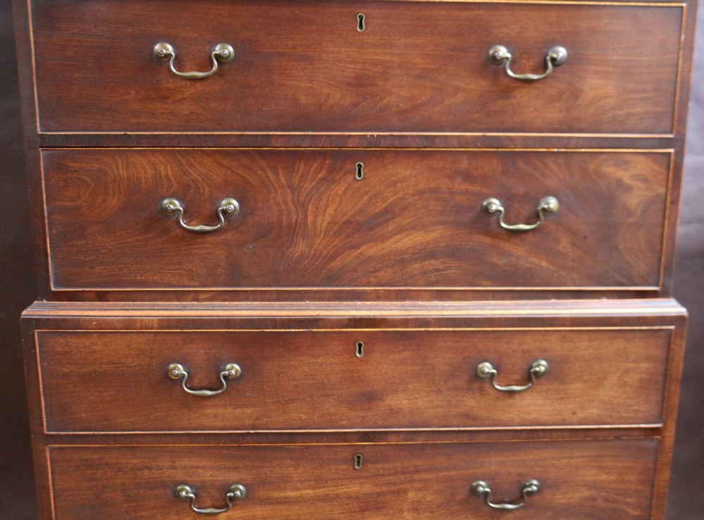 A George III mahogany chest on chest featuring two short over five long graduated drawers with brass swan-neck handles on bracket feet. View V