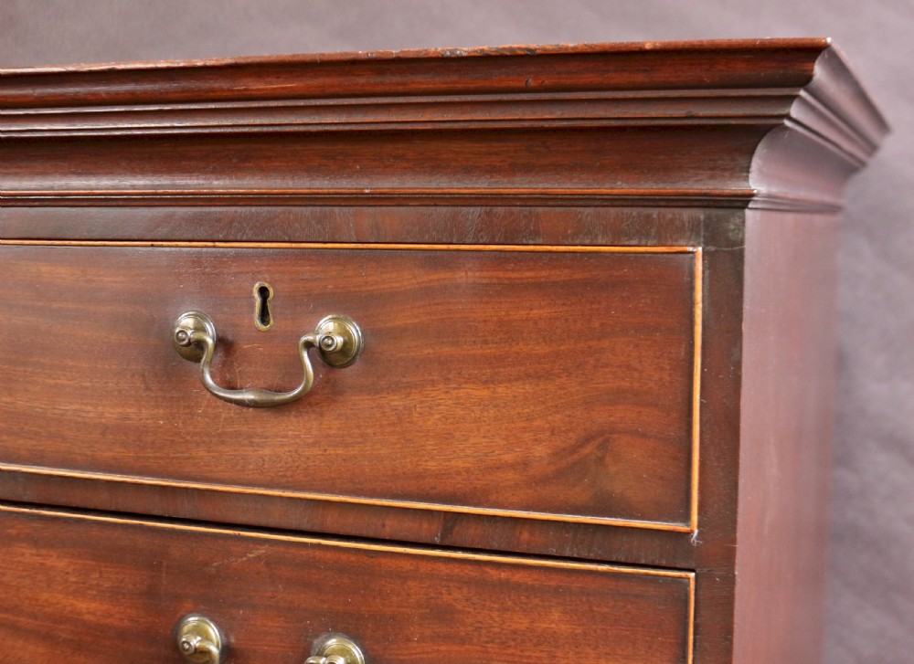 A George III mahogany chest on chest featuring two short over five long graduated drawers with brass swan-neck handles on bracket feet. View VI
