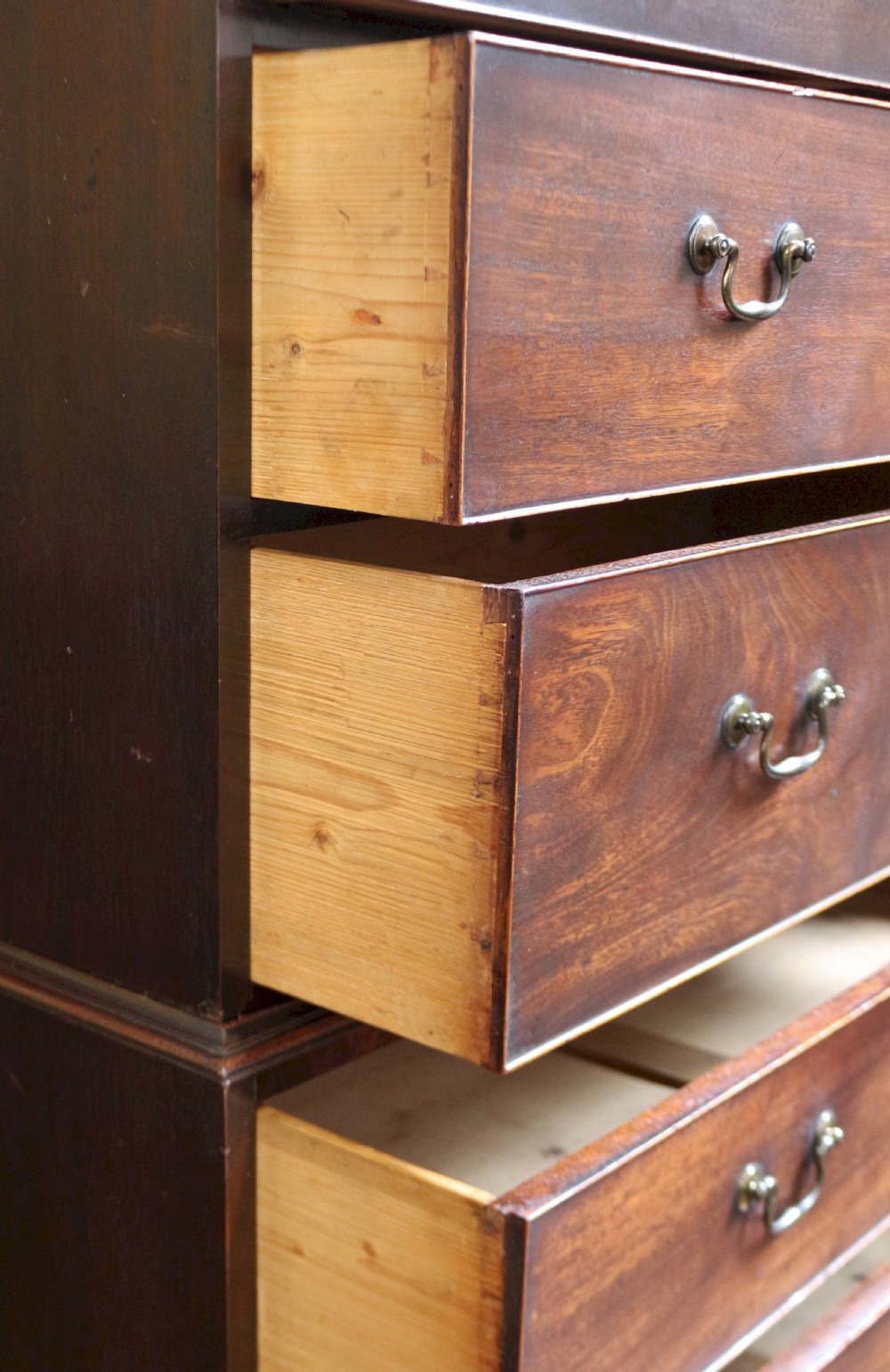 A George III mahogany chest on chest featuring two short over five long graduated drawers with brass swan-neck handles on bracket feet. View VII