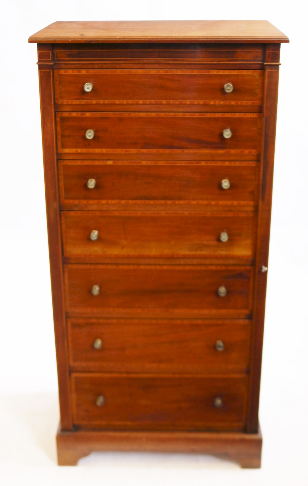 An Edwardian mahogany Wellington chest with seven drawers featuring light wood inlay and small round knobs.