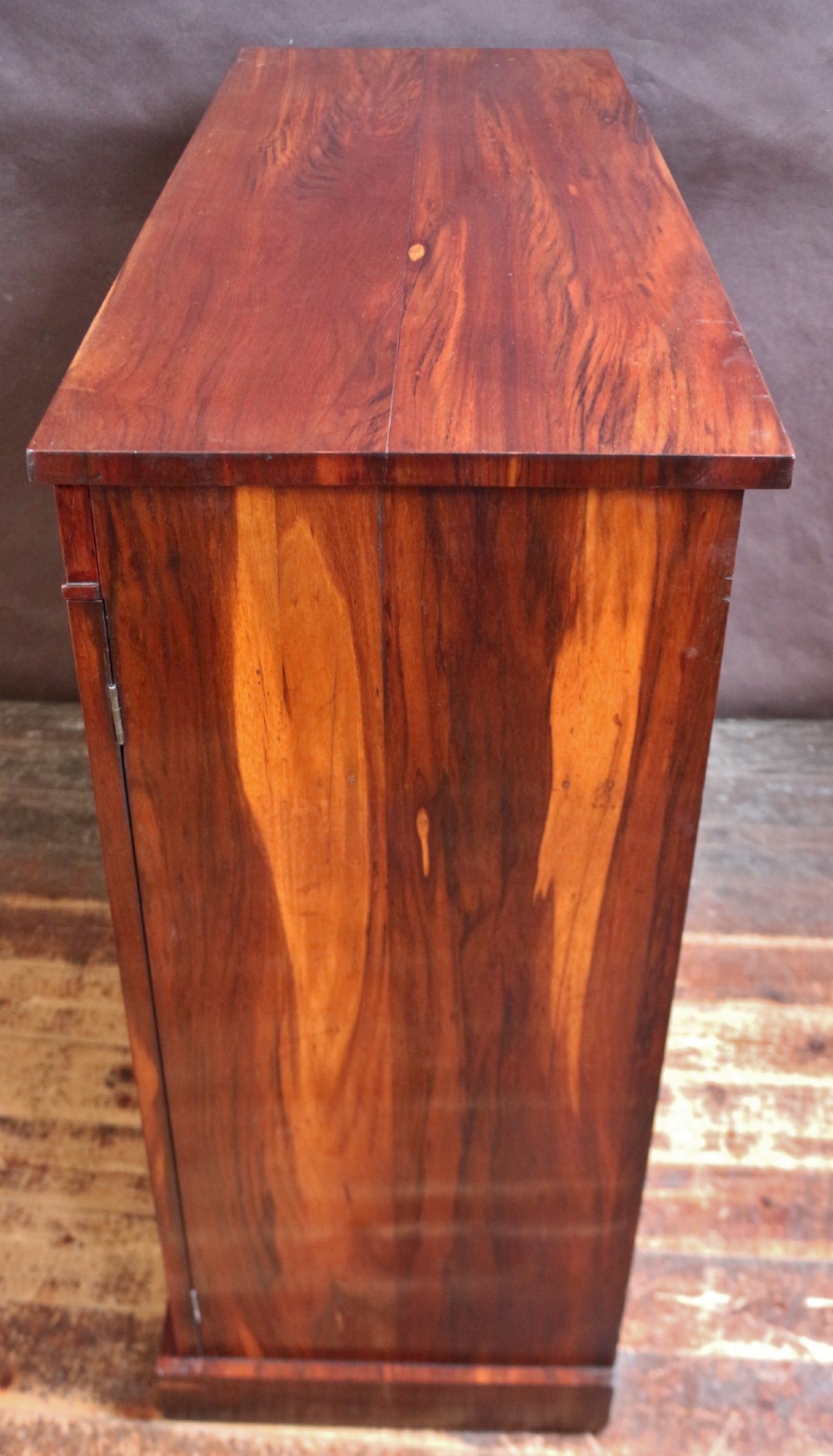 A George IV thuya wood side cabinet featuring two glazed doors, internal shelves, and a solid plinth base. View V