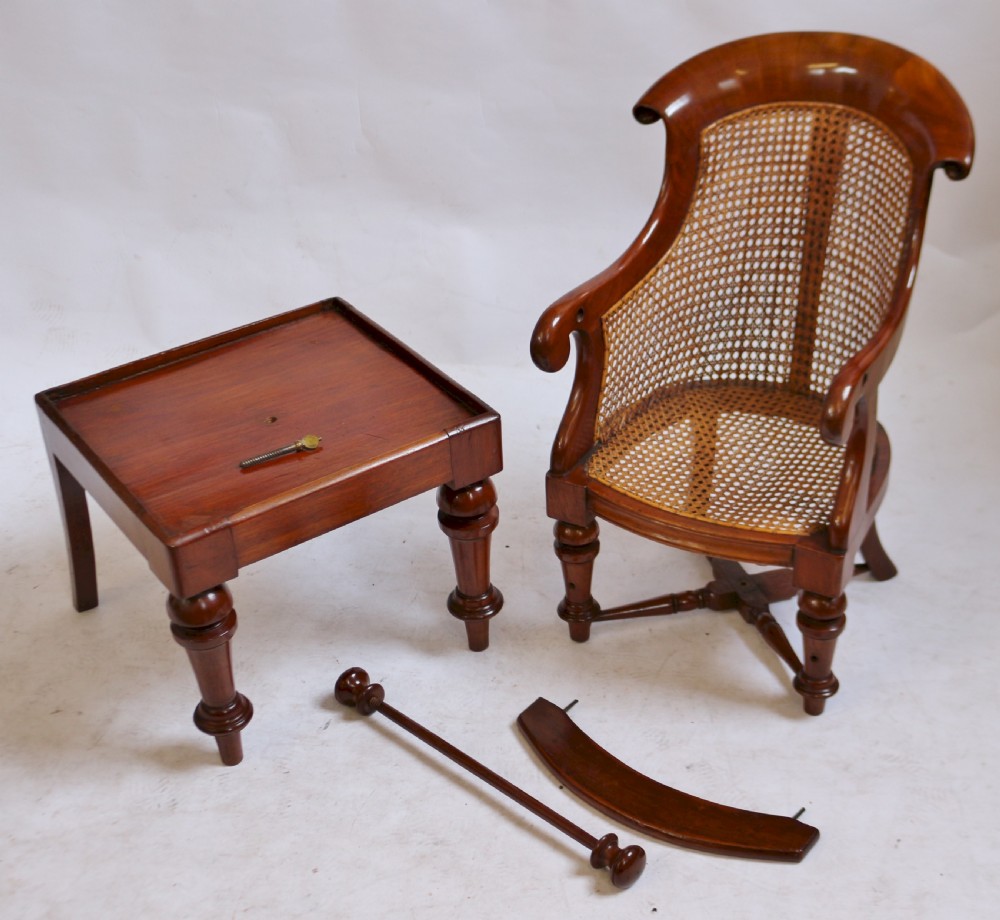 A Victorian mahogany childs high chair featuring a woven cane backrest and seat, turned legs, a protective front bar, and an integrated footrest. View V