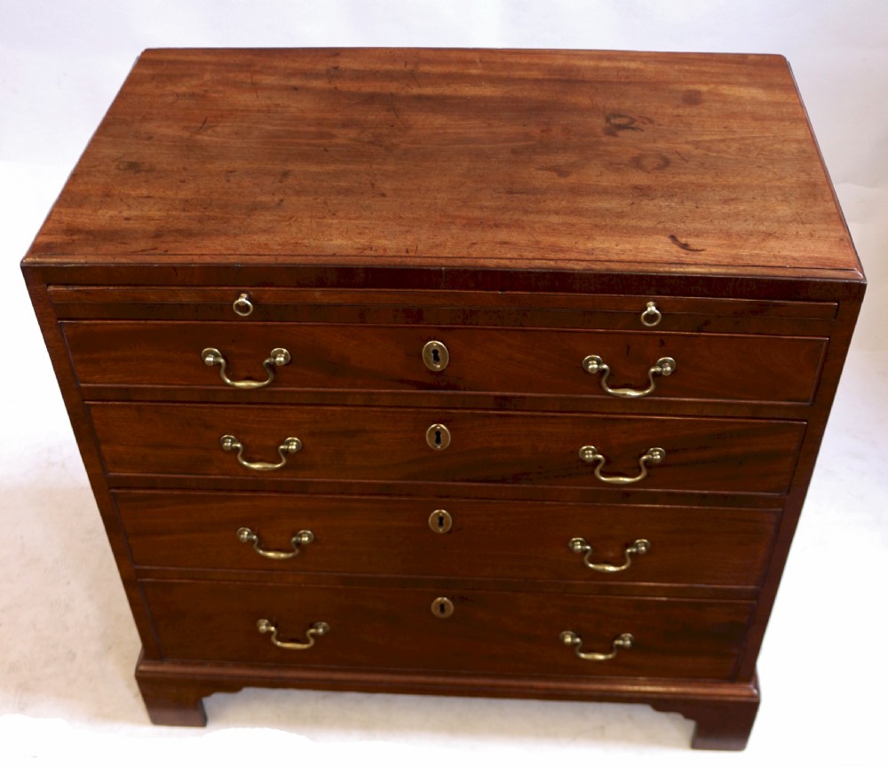 A Georgian mahogany chest of drawers featuring four graduated long drawers with brass swan-neck handles, a pull-out brushing slide, and classic bracket feet. View II