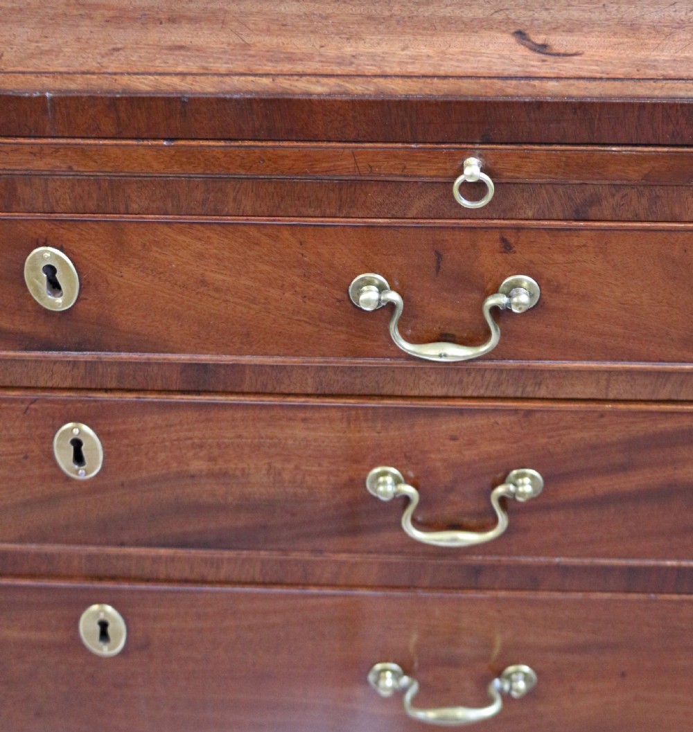 A Georgian mahogany chest of drawers featuring four graduated long drawers with brass swan-neck handles, a pull-out brushing slide, and classic bracket feet. View VIII