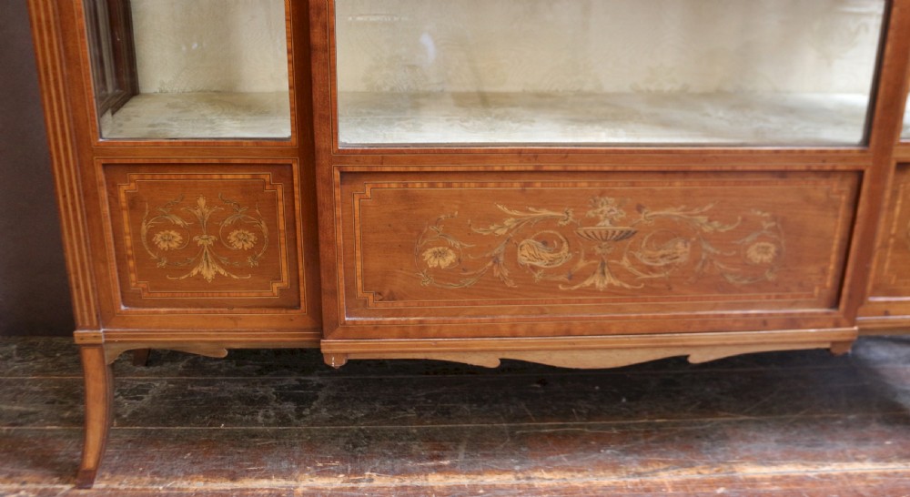 An antique mahogany display cabinet featuring satinwood floral marquetry, a single glazed door, side window panels, and a brass gallery along the top edge. View IX