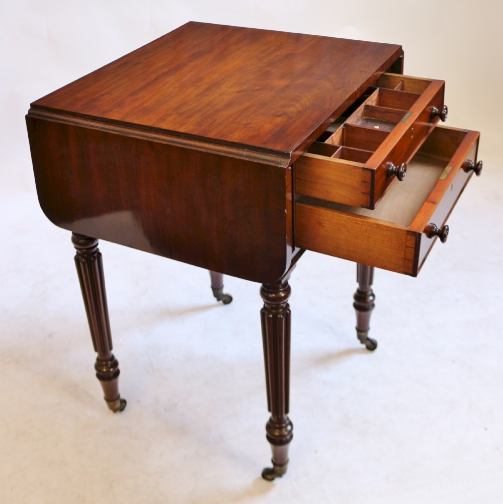 A William IV mahogany drop-leaf side table featuring two drawers with turned knobs, brass keyhole escutcheons, and reeded legs on brass castors. View IV
