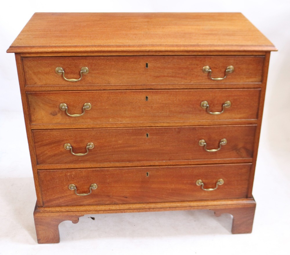 A George III mahogany four-drawer chest featuring brass swan-neck handles, keyhole escutcheons, and bracket feet.