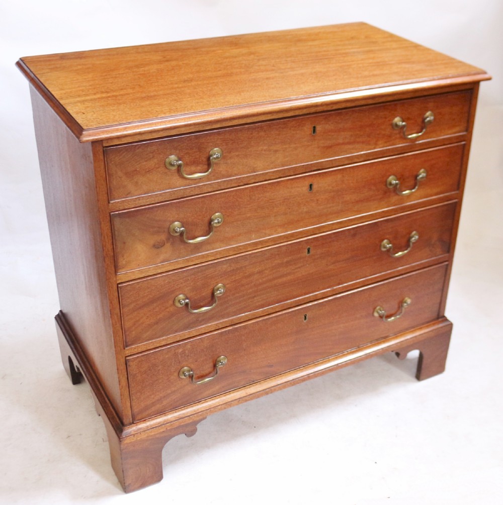A George III mahogany four-drawer chest featuring brass swan-neck handles, keyhole escutcheons, and bracket feet. View II