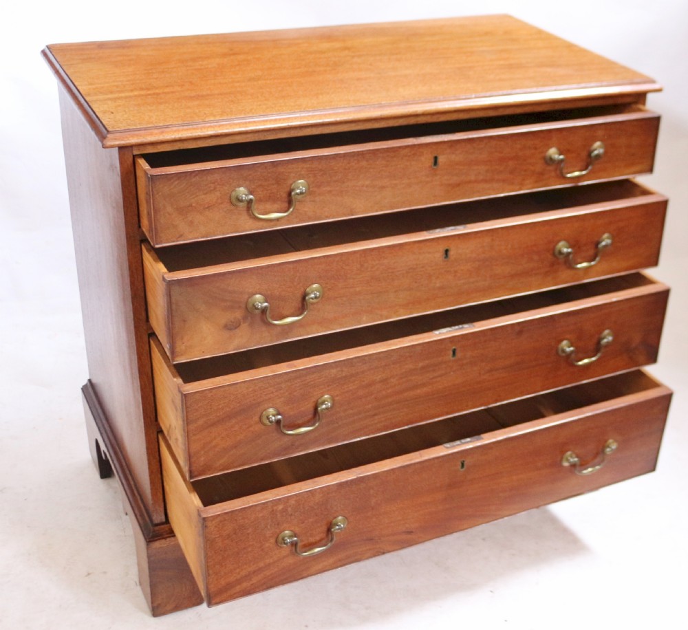 A George III mahogany four-drawer chest featuring brass swan-neck handles, keyhole escutcheons, and bracket feet. View III