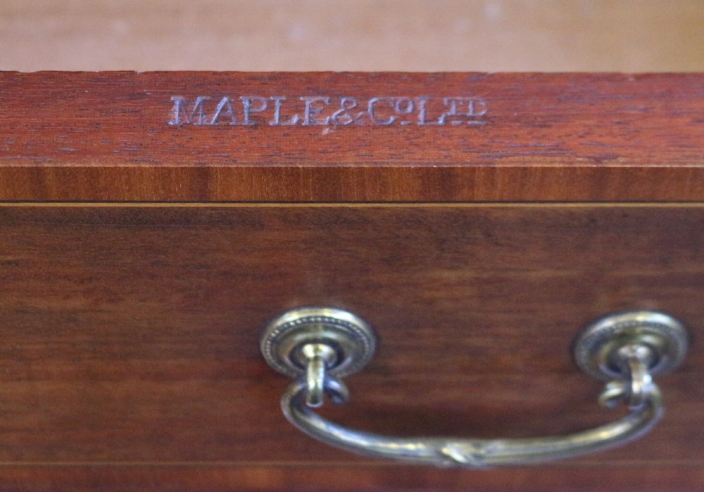 An Edwardian mahogany Wellington chest featuring seven stacked drawers with decorative wood inlay, brass drop handles, and a plinth base. View VI