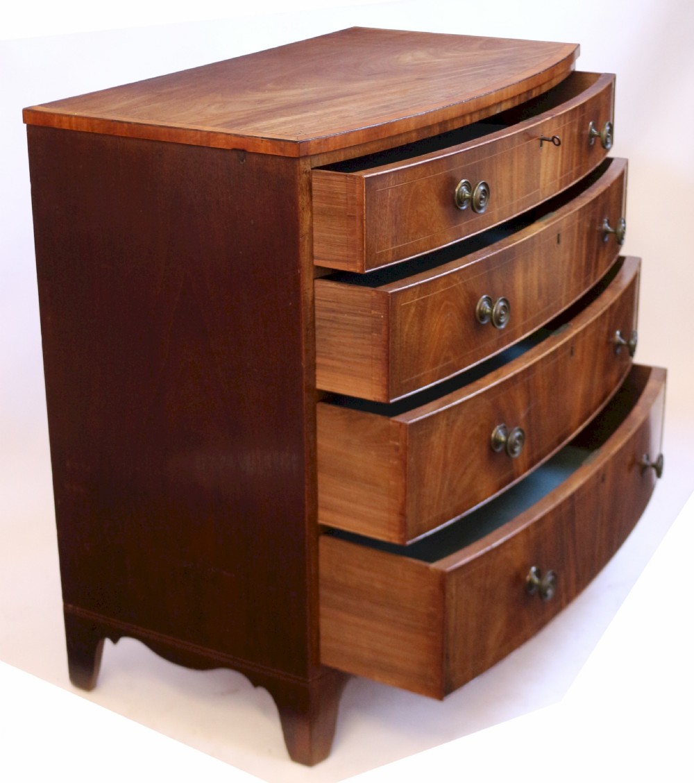 A George III mahogany bowfront chest of drawers featuring four graduated drawers with turned knobs and boxwood string inlay. View IV