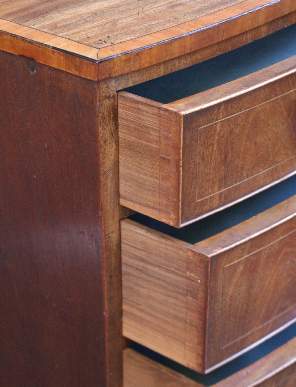 A George III mahogany bowfront chest of drawers featuring four graduated drawers with turned knobs and boxwood string inlay. View VII