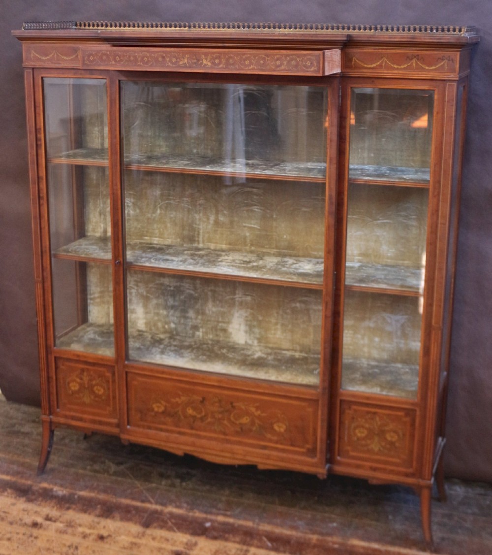 An Edwardian mahogany display cabinet featuring satinwood floral marquetry inlays, glazed doors and side panels, and square tapered legs. View XII