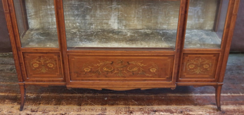 An Edwardian mahogany display cabinet featuring satinwood floral marquetry inlays, glazed doors and side panels, and square tapered legs. View XIII