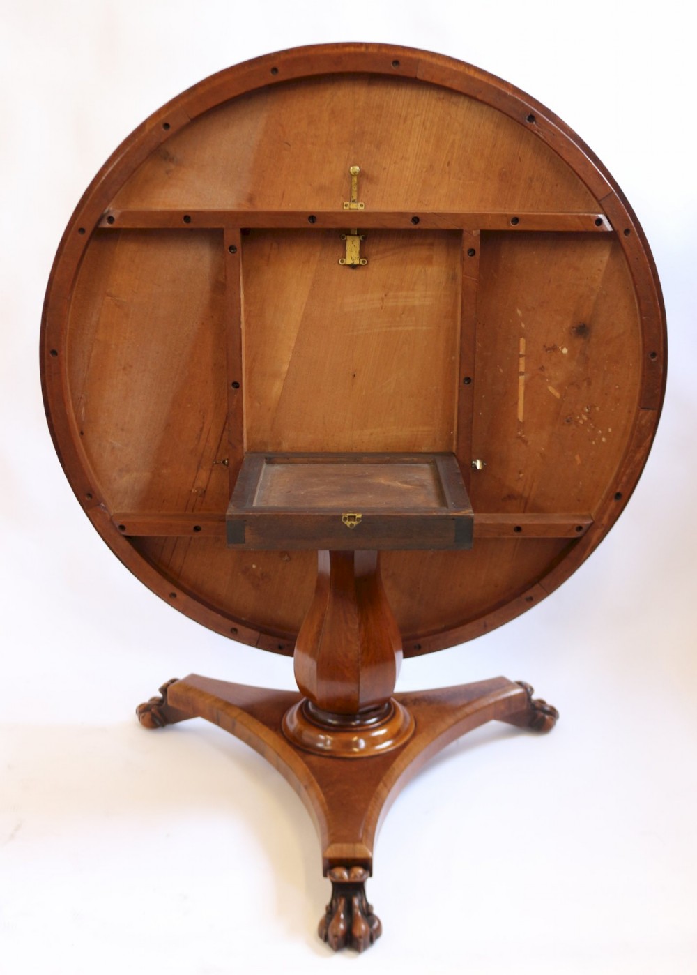 A William IV circular mahogany centre table featuring a sunburst veneered top, a central faceted column, and a triform plinth base supported by carved lion paw feet. View III