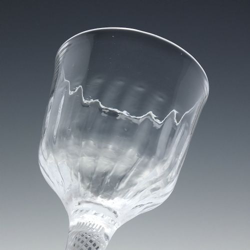 fig 3. An 18th-century clear glass wine glass featuring a multi-spiral opaque white twist stem with a central knop and a round foot.