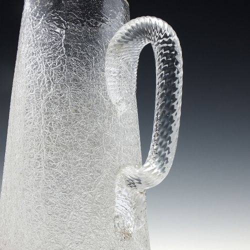 fig 1. A late 19th-century clear overshot glass water jug featuring a textured ice-like body, a twisted applied glass handle, and a subtle gilded rim.