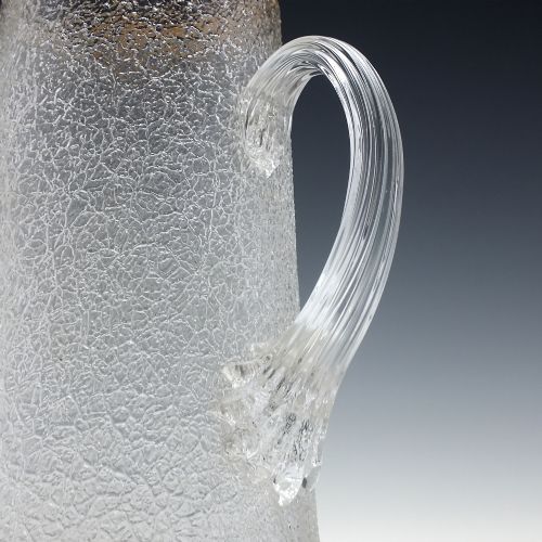 fig 1. A tall nineteenth-century clear overshot glass water jug featuring a textured ice surface, an applied ribbed handle, and a gilded gold rim.