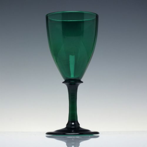 fig 1. A mid-nineteenth-century wine glass made from deep emerald green glass with a slender stem and flat circular foot.