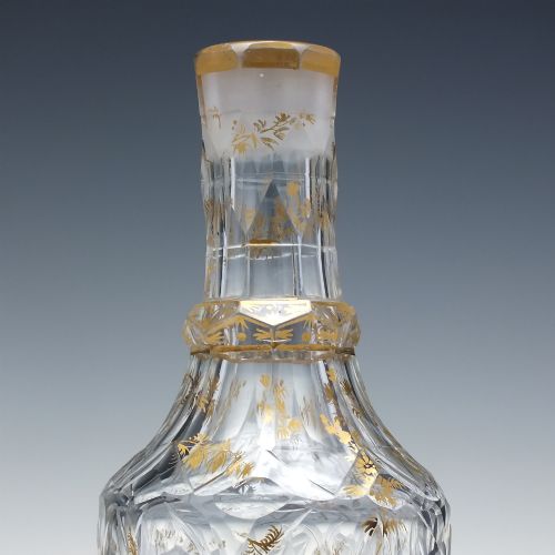 fig 2. A clear cut glass decanter with gilded lettering on the shoulder, a diamond facetted body, and a facetted glass stopper.
