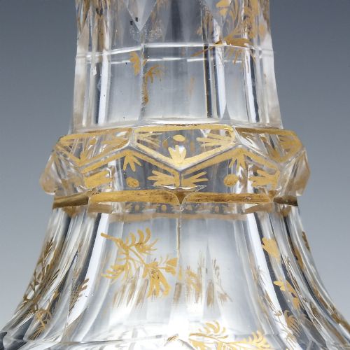 fig 4. A clear cut glass decanter with gilded lettering on the shoulder, a diamond facetted body, and a facetted glass stopper.