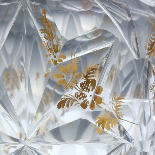 fig 7. A clear cut glass decanter with gilded lettering on the shoulder, a diamond facetted body, and a facetted glass stopper.